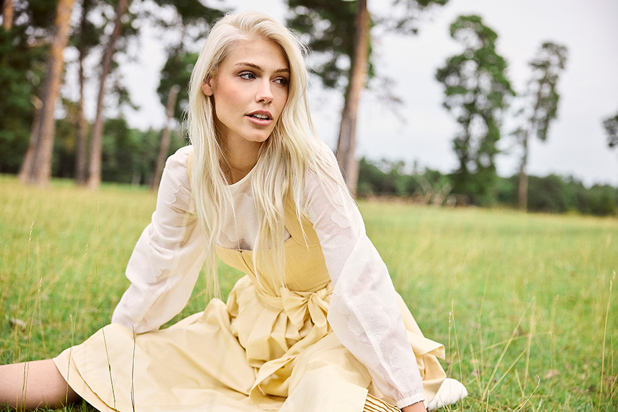 Schlichte Eleganz in Pure Yellow | Der Schnitt und der hochwertige Baumwollstoff des Dirndls „Hermine“ sorgen für ein angenehmes Tragegefühl. Wobei das verstärkte Mieder mit Hakenverschluss eine feminine Silhouette zaubert. Der Rock mit Biesen und die dezent gemusterte Schürze runden den klassischen Look stilvoll ab. Hier kombiniert mit der Bluse „Margarethe Floral“ aus der exklusiven CocoVero x Windsor Capsule Collection. | www.cocovero.com | Foto: © CocoVero GmbH